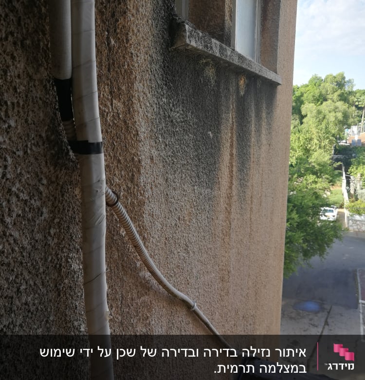 צינור מים חיצוני מחובר לקיר בניין